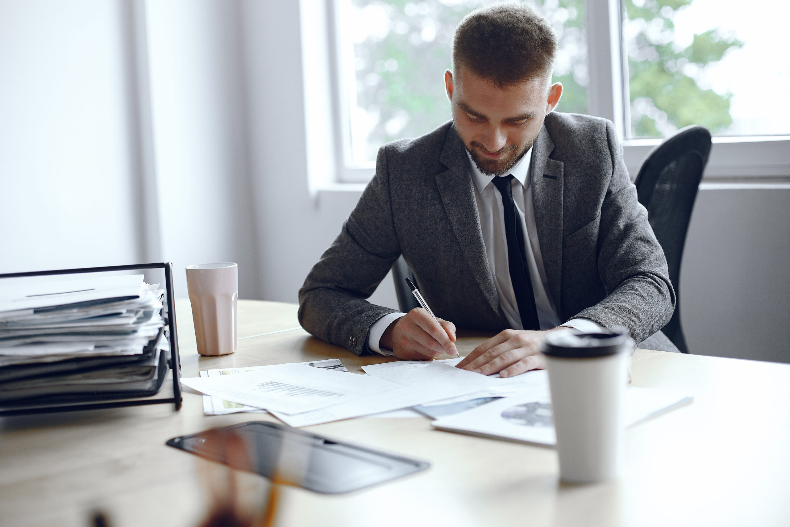 Empresário conferindo documentos para o contador e utilizando software de integração financeira.