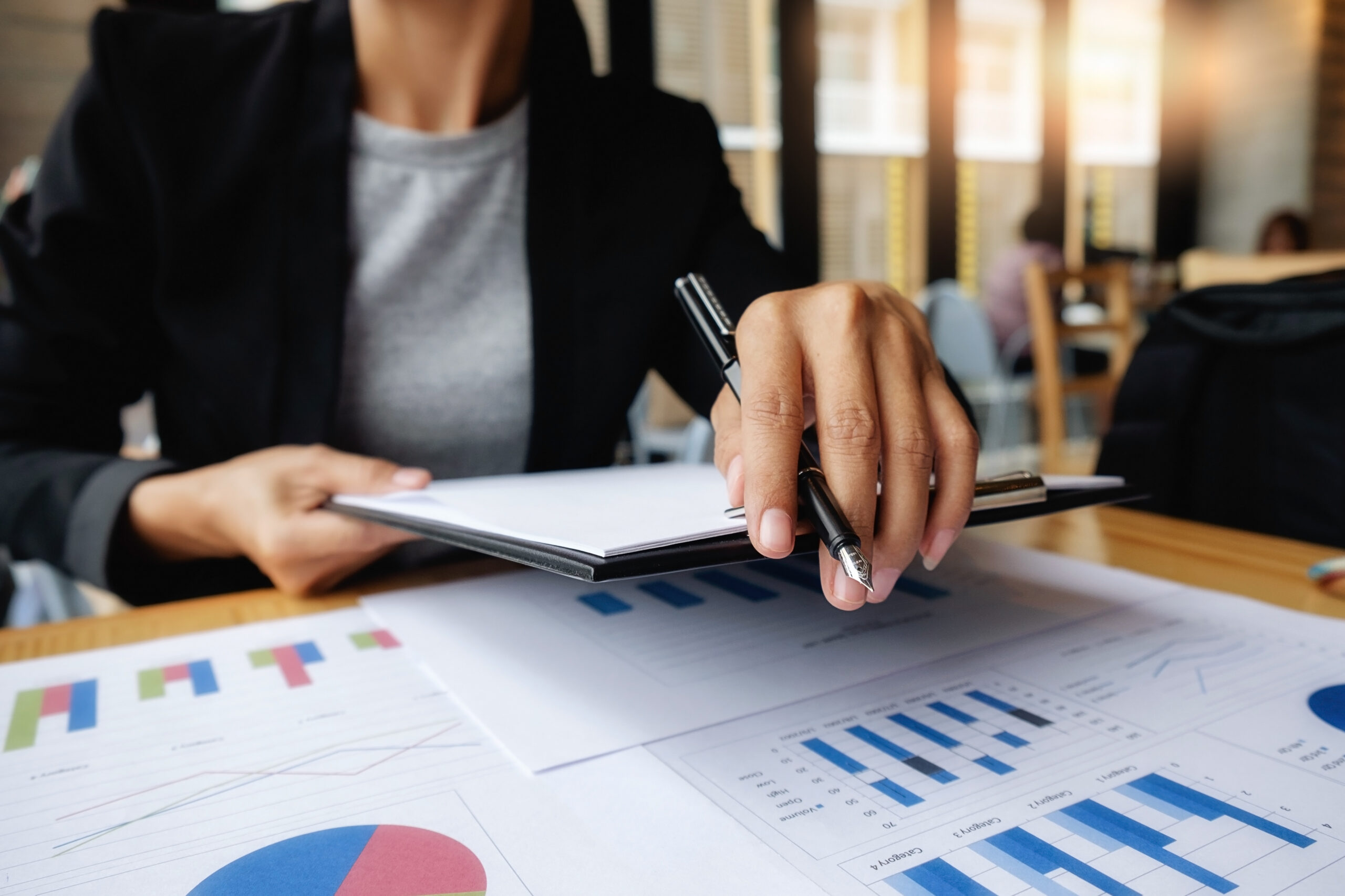 Empresário marcando datas importantes no calendário do ciclo fiscal e analisando planilhas.