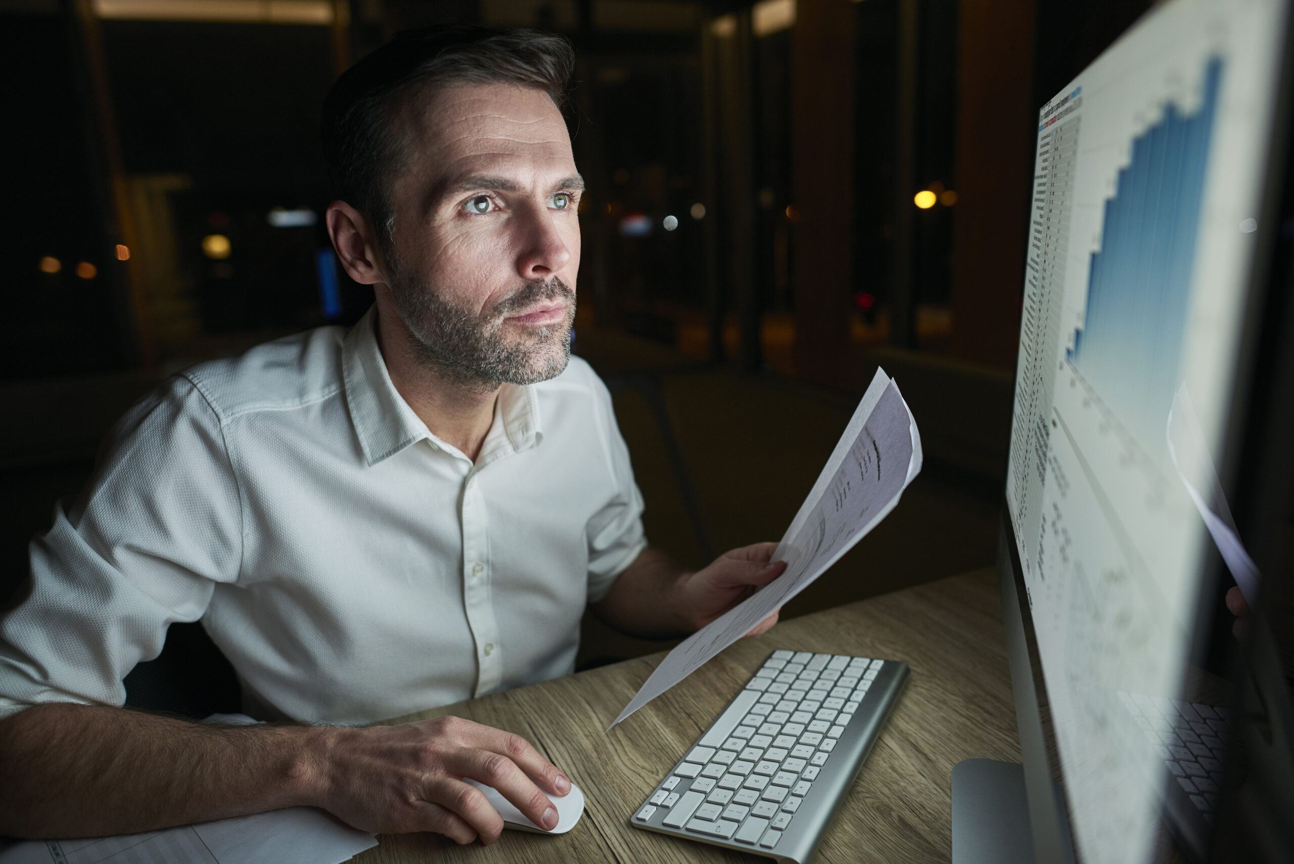 Focused Man With Document Using Computer - CONTABILIDADE CARIOCA