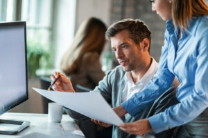 Businessman And His Female Colleague Working On Reports In The Office. - CONTABILIDADE CARIOCA